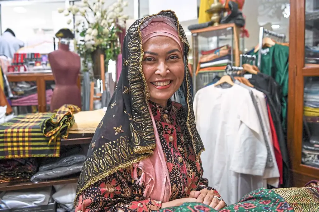 A traditional Baju Kurung in vibrant batik fabric, highlighting intricate embroidery and floral motifs